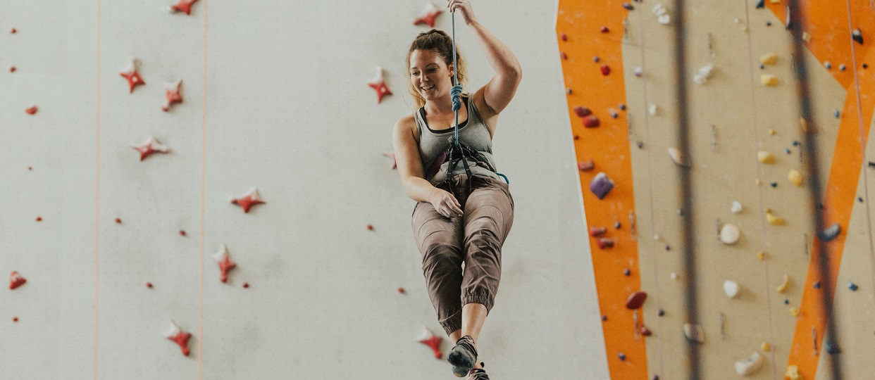 Woman abseiling at indoor climbing centre