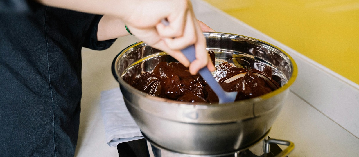 stirring melted chocolate in a metal bowl